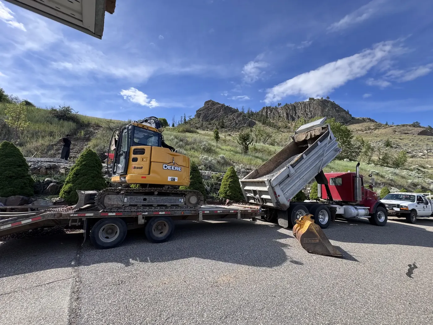 Dump truck unloading material beside excavation equipment
