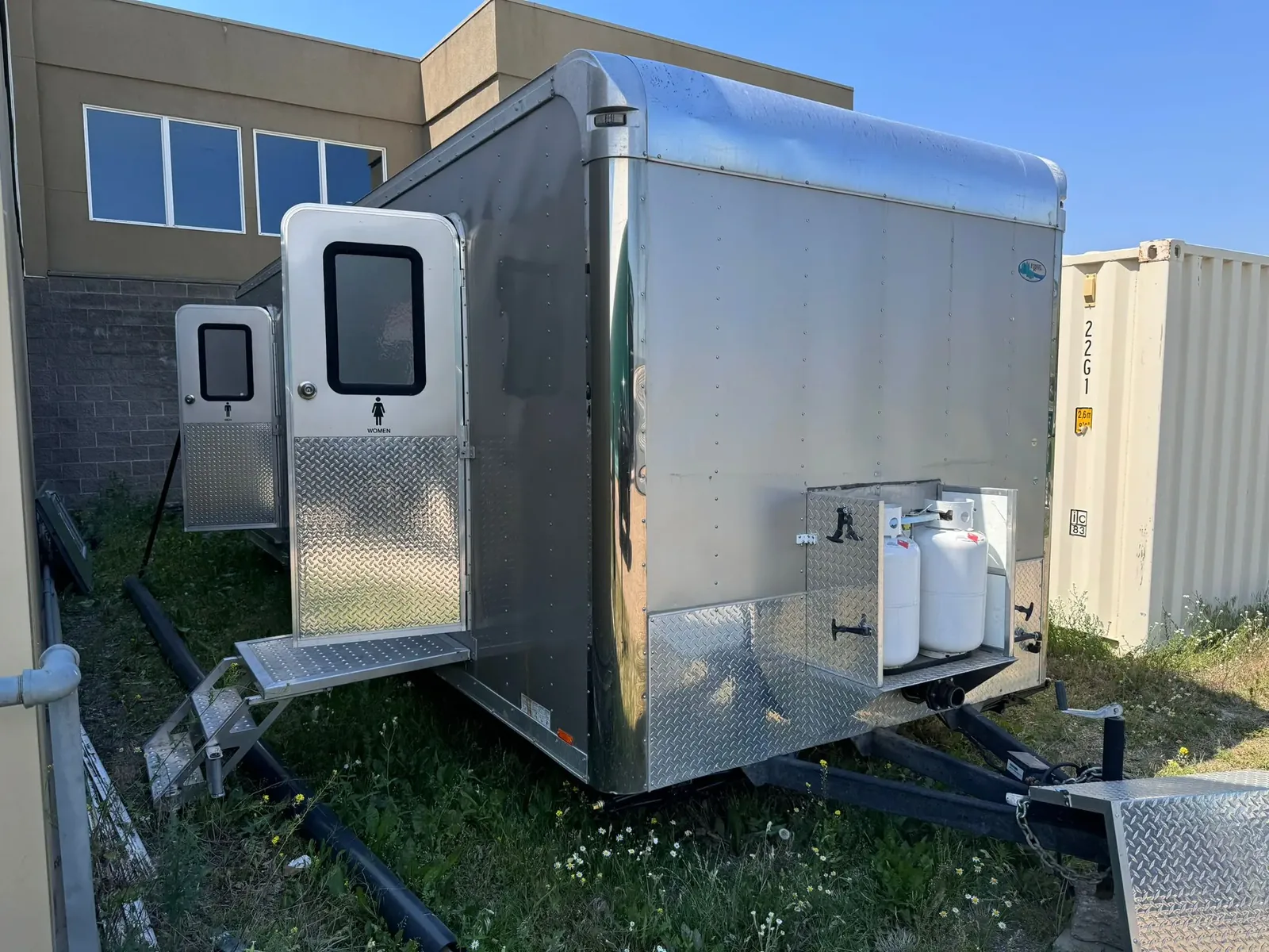 Restroom trailer with separate entrances and access steps